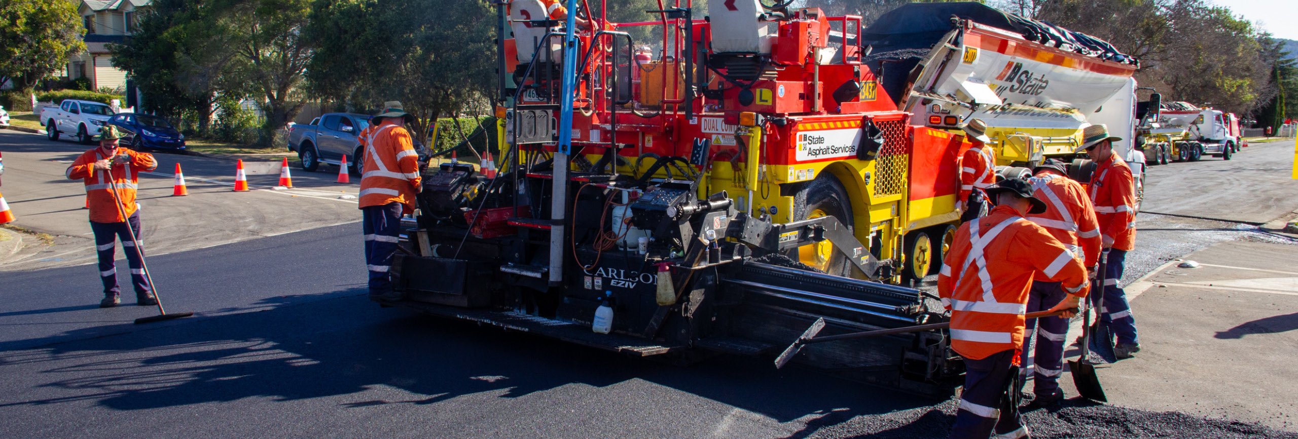 Workmen laying glassphalt on road