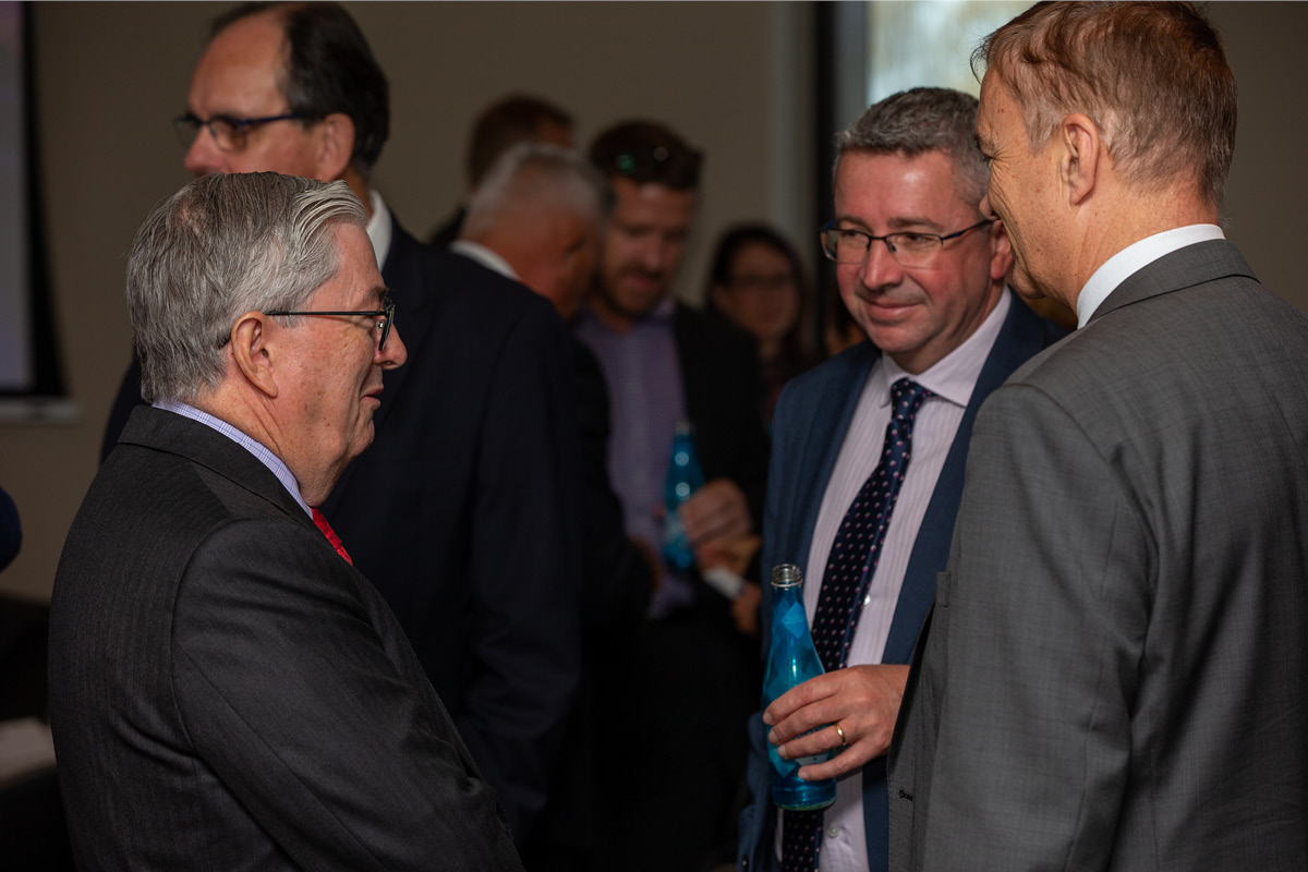 Three men talking at indoor meeting