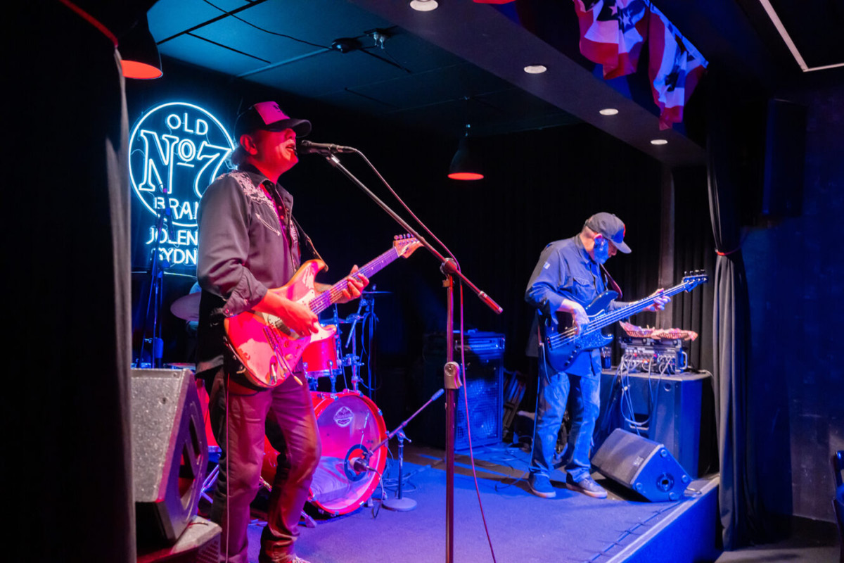 Image of a band on a small stage performing live music at a venue