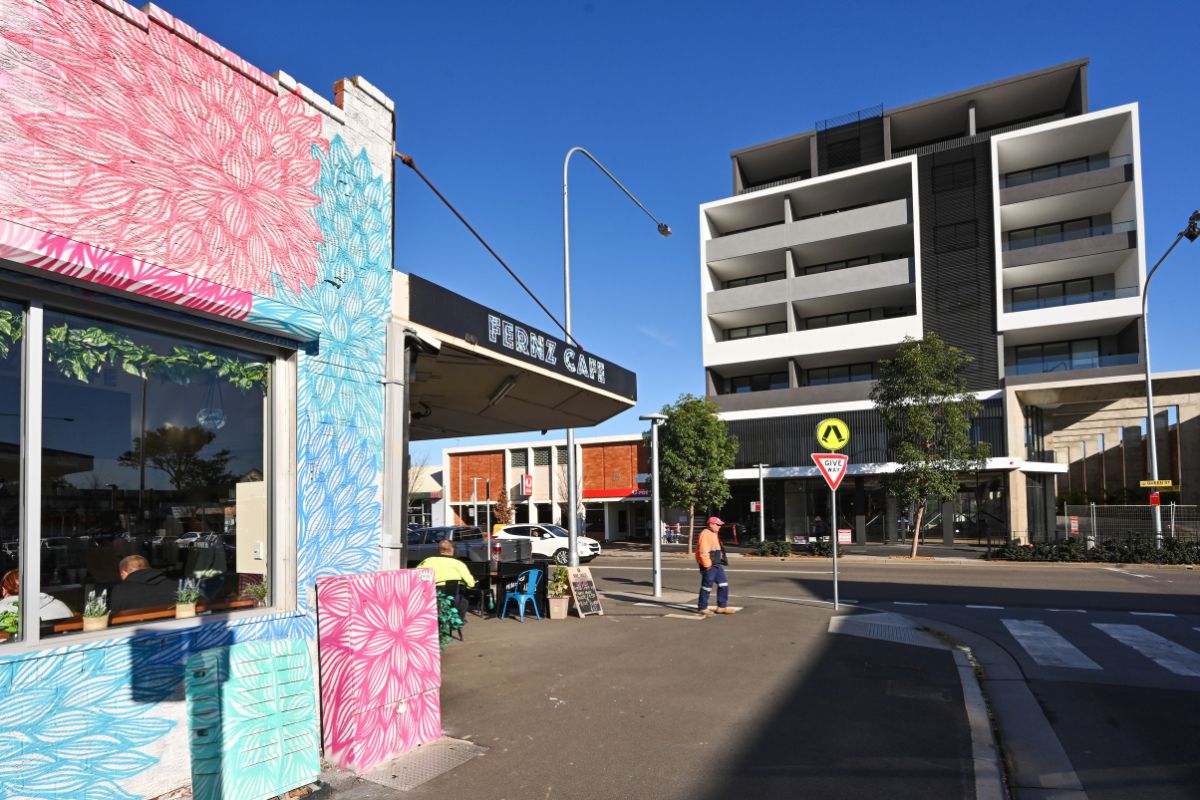 city street with building in foreground covered in painted mural