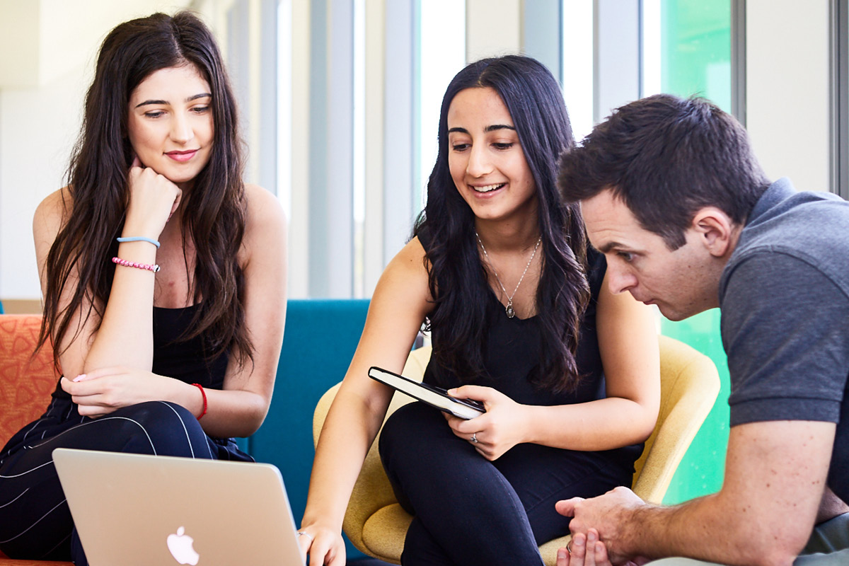 Two women and one man working collaboratively with a laptop