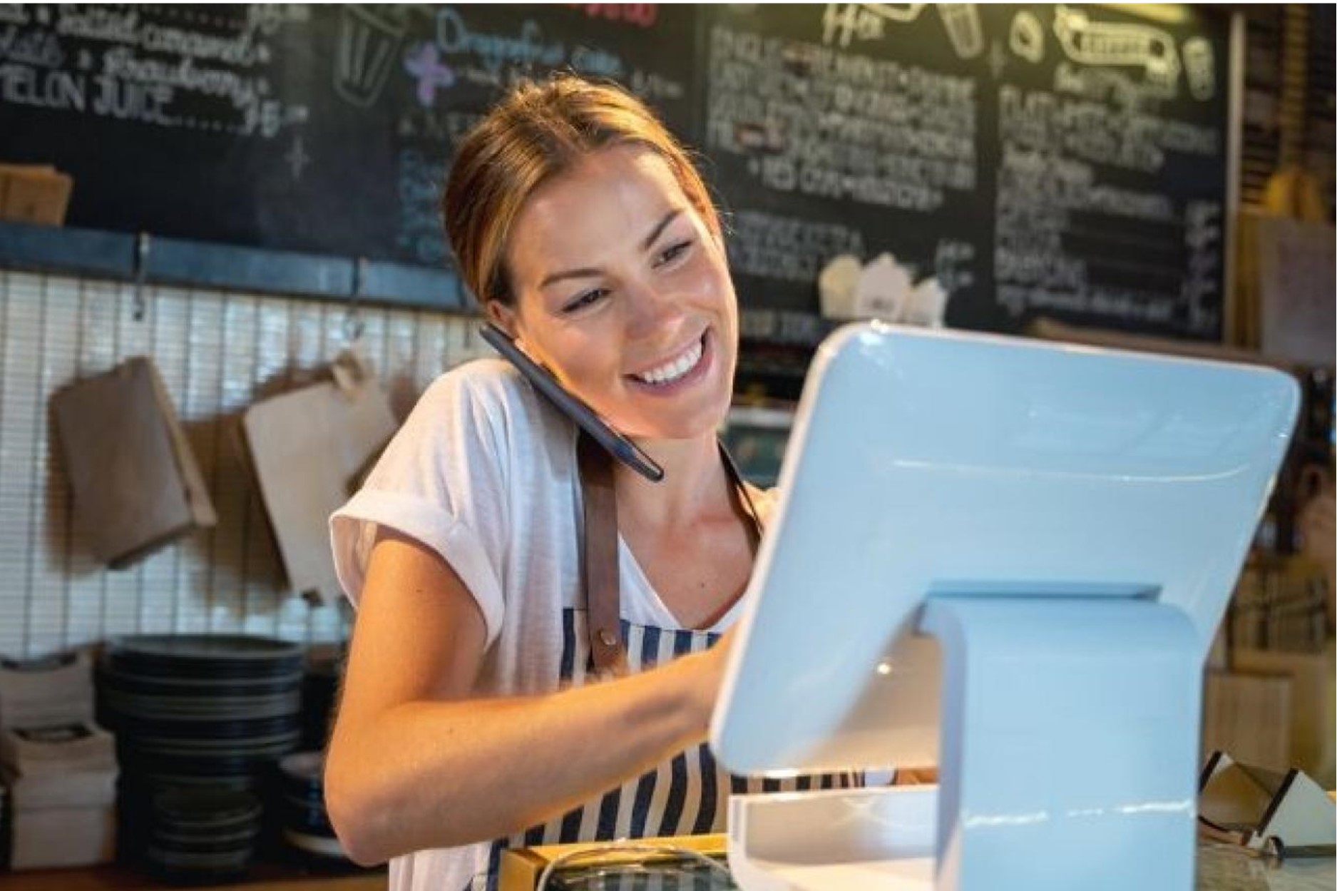 woman at cafe counter talking on phone