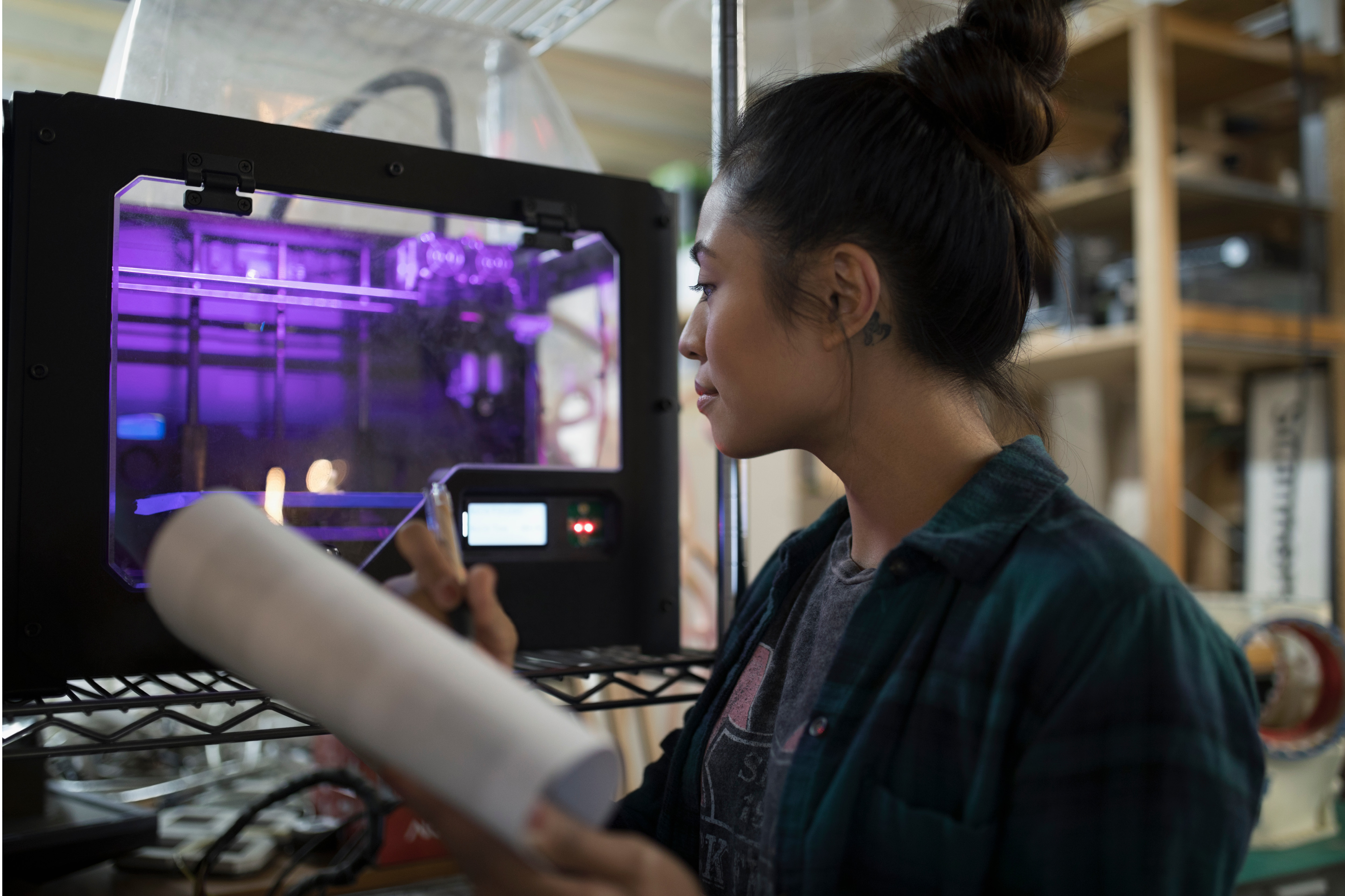 woman holding paper looking at machine